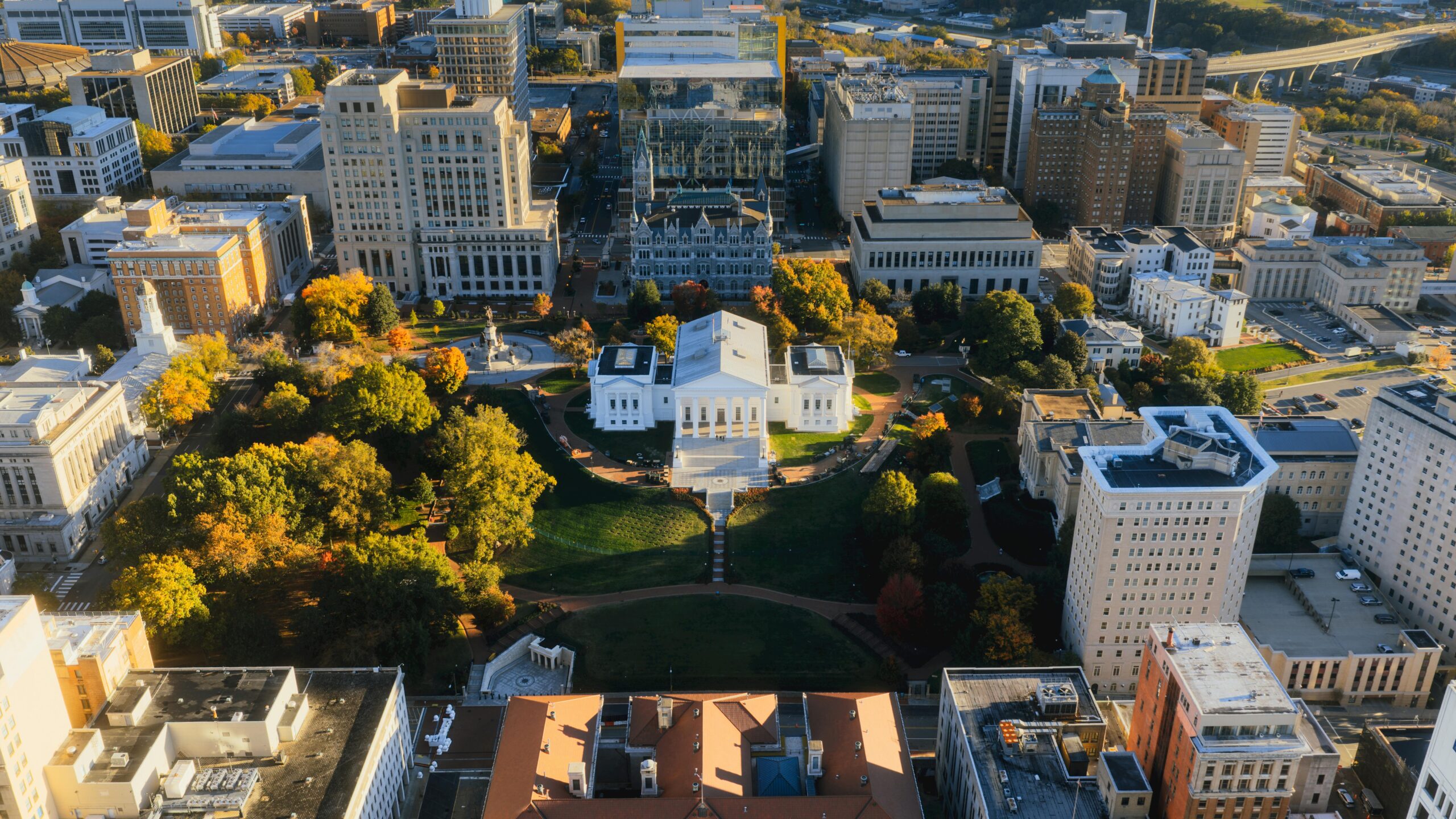 Stunning aerial view of the Virginia State Capitol surrounded by vibrant autumn foliage in downtown Richmond.